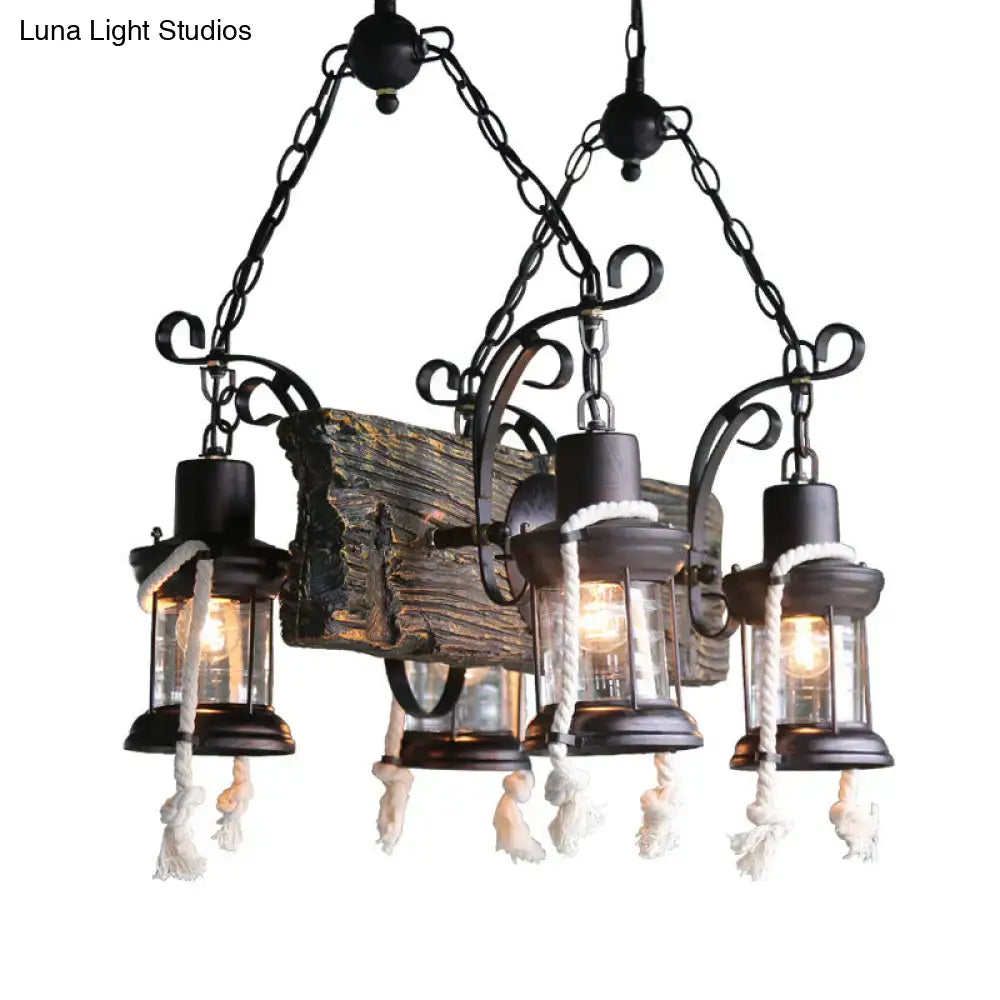 Black wrought iron island lamp with three lantern lights, glass enclosures, and white hemp rope tassels at bulb base