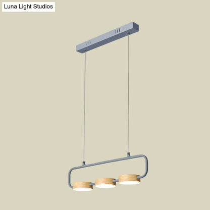 Modern minimalist hanging pendant with gray metal frame and wooden shades providing warm light for kitchen island