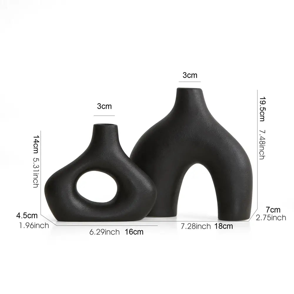 Two sleek matte black nordic ceramic vases home decor with organic asymmetrical shapes and minimalist design by DecorBites
