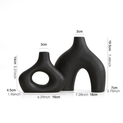 Two sleek matte black nordic ceramic vases with asymmetrical shapes for elegant vases home decor by decorbites
