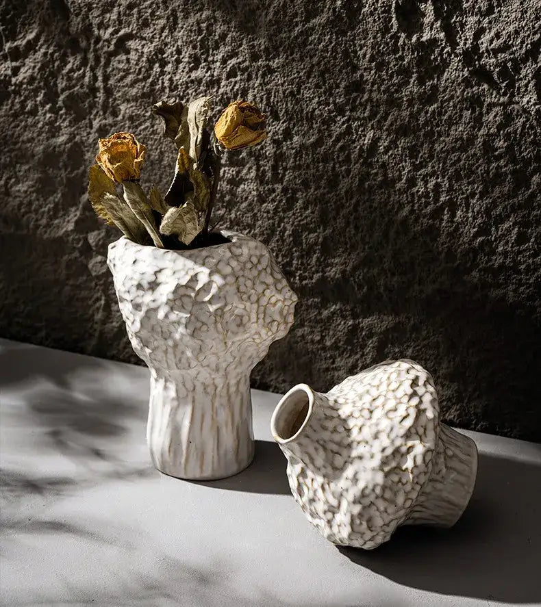 White ceramic nordic ceramic vase with textured pebbled surface and organic asymmetrical shape with pampas grass
