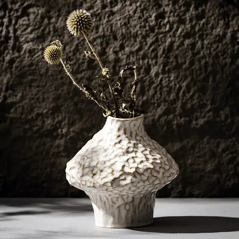 White ceramic nordic ceramic vase by DecorBites with a textured organic surface and bulbous shape displayed with pampas grass