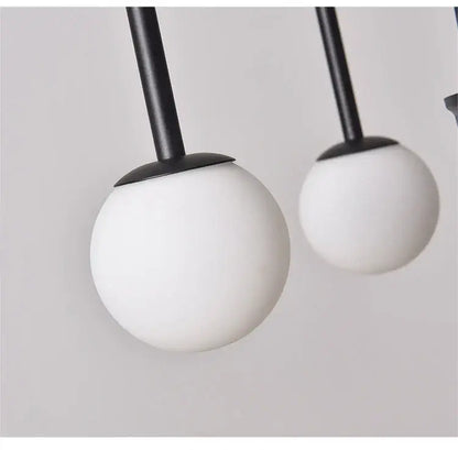 Modern black and white spherical pendant lights with matte-finished glass globes in DecorBites™ comet chandelier nordic design