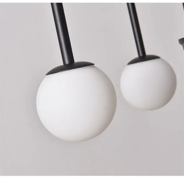 Modern black and white spherical pendant lights with matte-finished glass globes in DecorBites™ comet chandelier nordic design