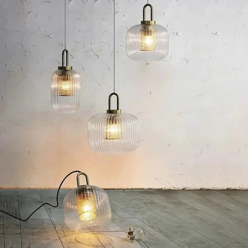 Three clear glass pendant lights with vertical ridges and brass accents complement decorbites™ nordic deer head wall lamp