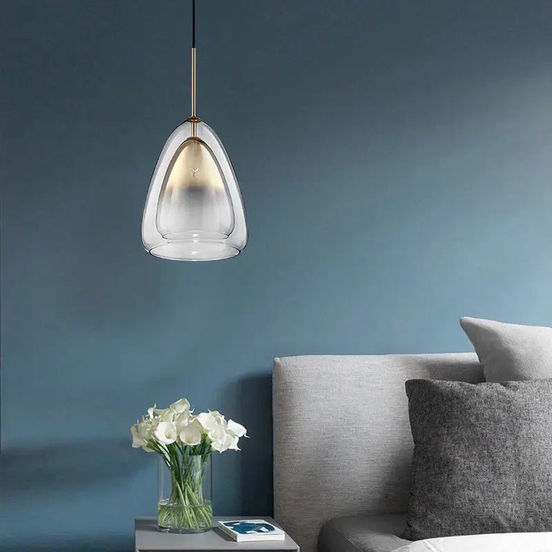 DecorBites Nordic pendant light fixture with clear glass shade and brass champagne suspension above bedside table