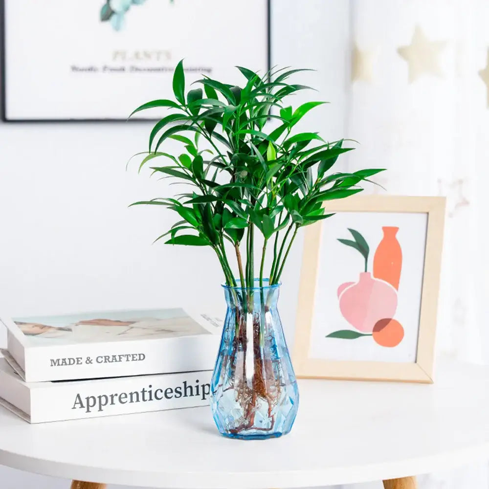 DecorBites™ nordic flower vase is a translucent blue glass vase with a faceted design holding a green plant for modern home decor