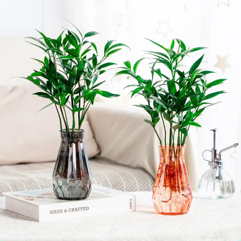 Two decorbites™ nordic flower vases in dark gray faceted and translucent orange with green plants for modern home decor