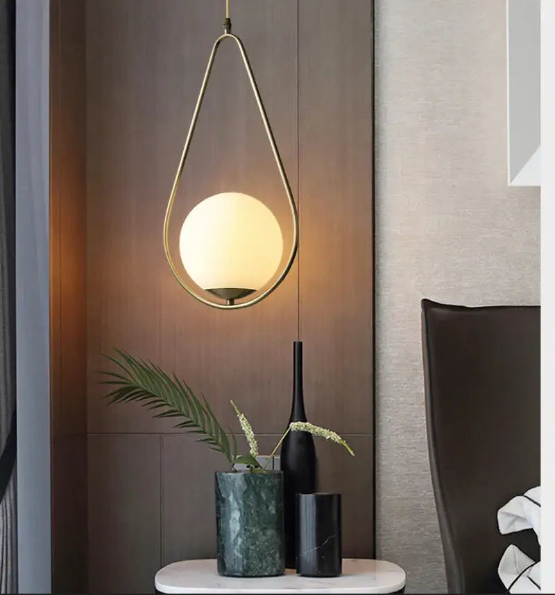 DecorBites™ Nordic glass ball pendant light features a gold-toned teardrop fixture with a frosted glass globe light source