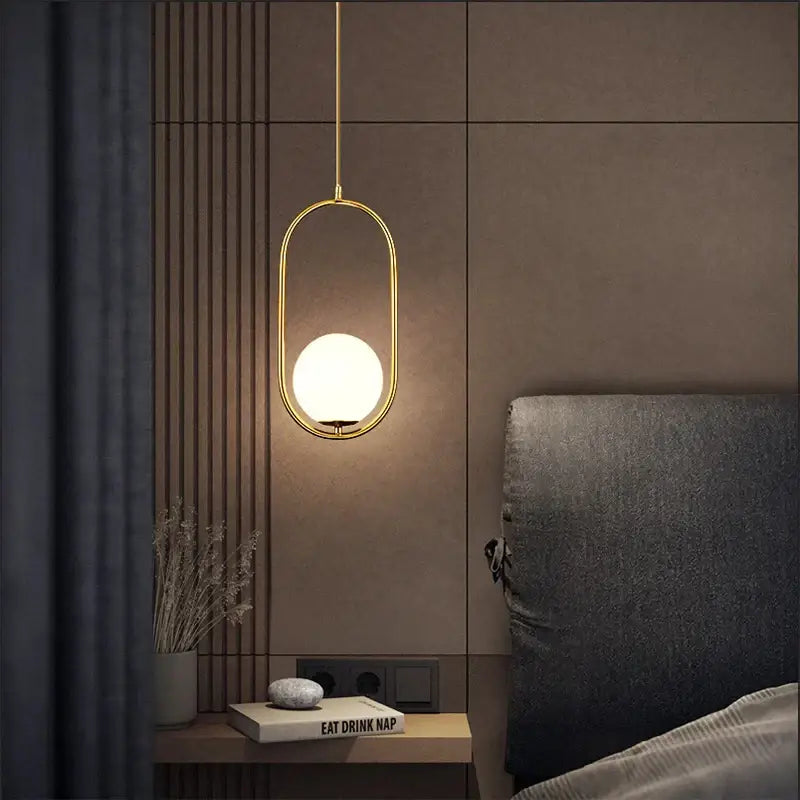 Gold-toned decorbites™ nordic pendant light with frosted glass ball light source in an oval design