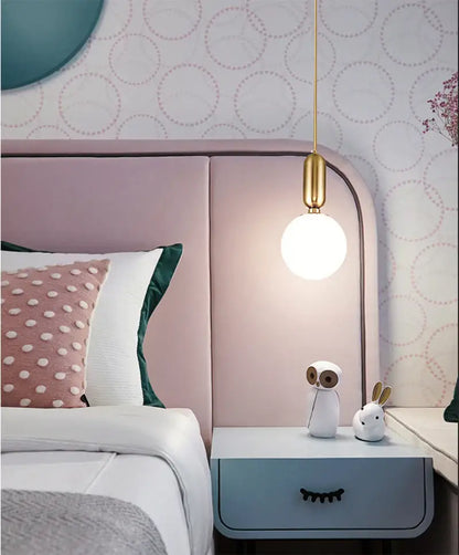 DecorBites™ Nordic pendant light with a white glass ball and polished gold fixture as a bedside light source