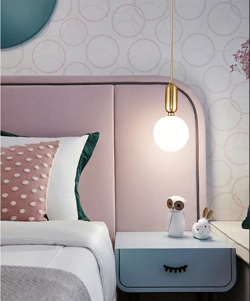 DecorBites™ Nordic pendant light with a white glass ball and polished gold fixture as a bedside light source
