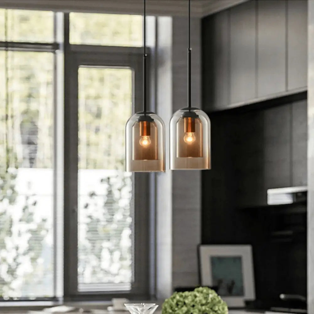Two amber-tinted glass pendant lights with black cords in decorbites™ nordic glass pendant lighting design
