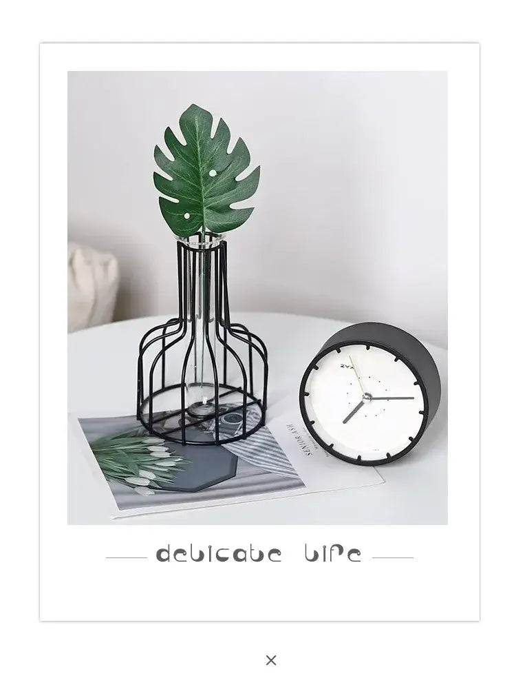 Black wireframe vase holding a green monstera leaf from DecorBites™ nordic iron golden hydroponic vase with dried flowers