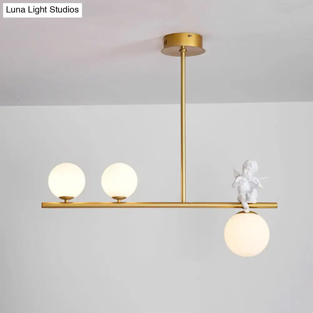 Gold-toned DecorBites™ Nordic Island Angel pendant light with opaline glass shade and white cherub figurine detail