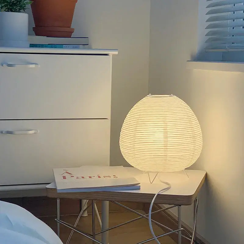 Warmly glowing white paper lantern led table lamp with minimalist egg-shaped design for bedroom and living study use