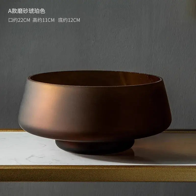 A matte-finished warm bronze ceramic bowl shown with a decorbites™ nordic luxe frosted glass vase table decoration