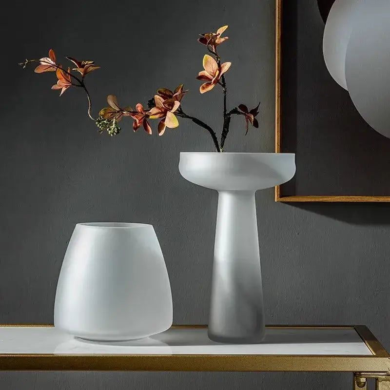 A sleek frosted glass vase by decorbites with a modern pedestal base and wide rim for table decoration