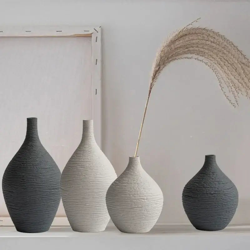 Set of four matte gray and off-white nordic luxury ceramic vases with ribbed texture and slender necks for home décor