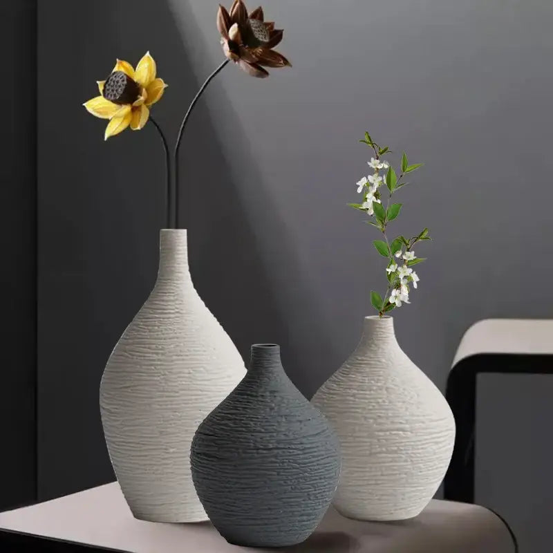 Three textured white and gray ceramic vases with dried flowers in nordic luxury ceramic design for home décor