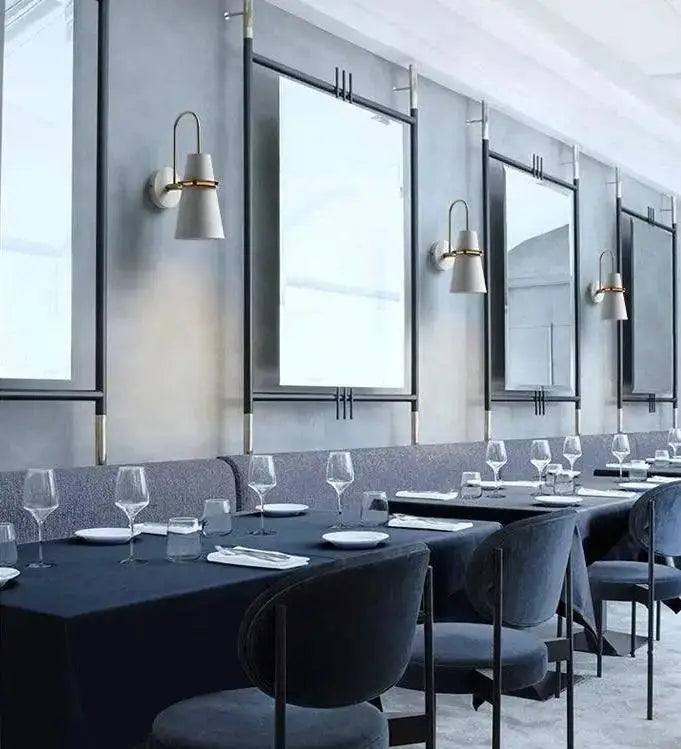 Black velvet banquet chairs with sleek metal frames complement the decorbites™ nordic minimalist wall lamp design