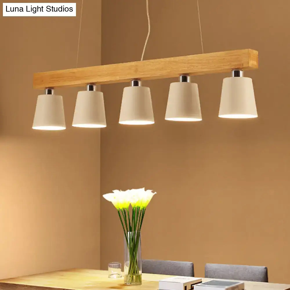 Modern rectangular wooden pendant light with five off-white fabric shades and metal lampshade accents for work rooms