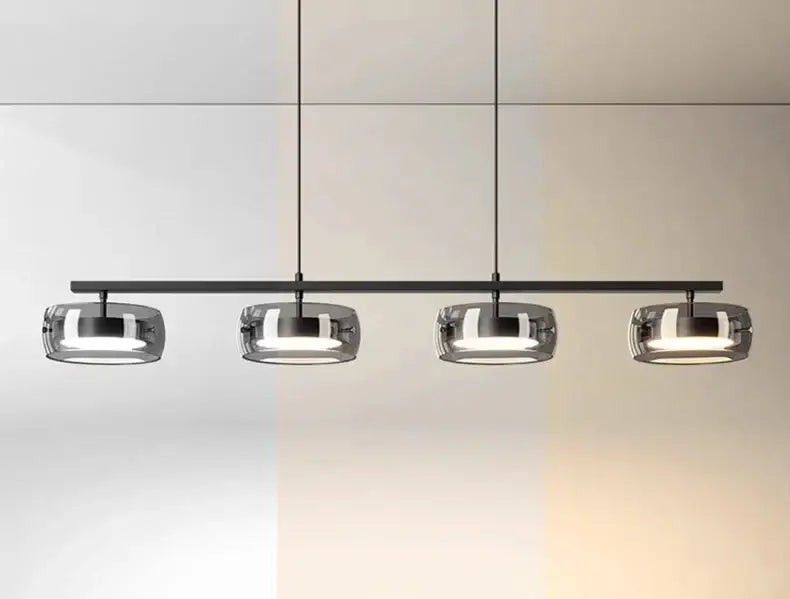 Modern black metal pendant lamp with four frosted glass shades emitting warm white light for dining and living rooms