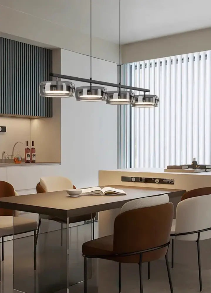 Modern minimalist pendant lamp DecorBites™ with four cylindrical glass shades and black metal frame for dining rooms in warm white