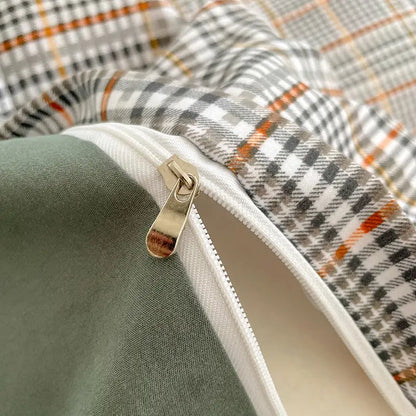 A metallic zipper with a silver pull tab on a nordic plaid cotton bedding set with olive green lining