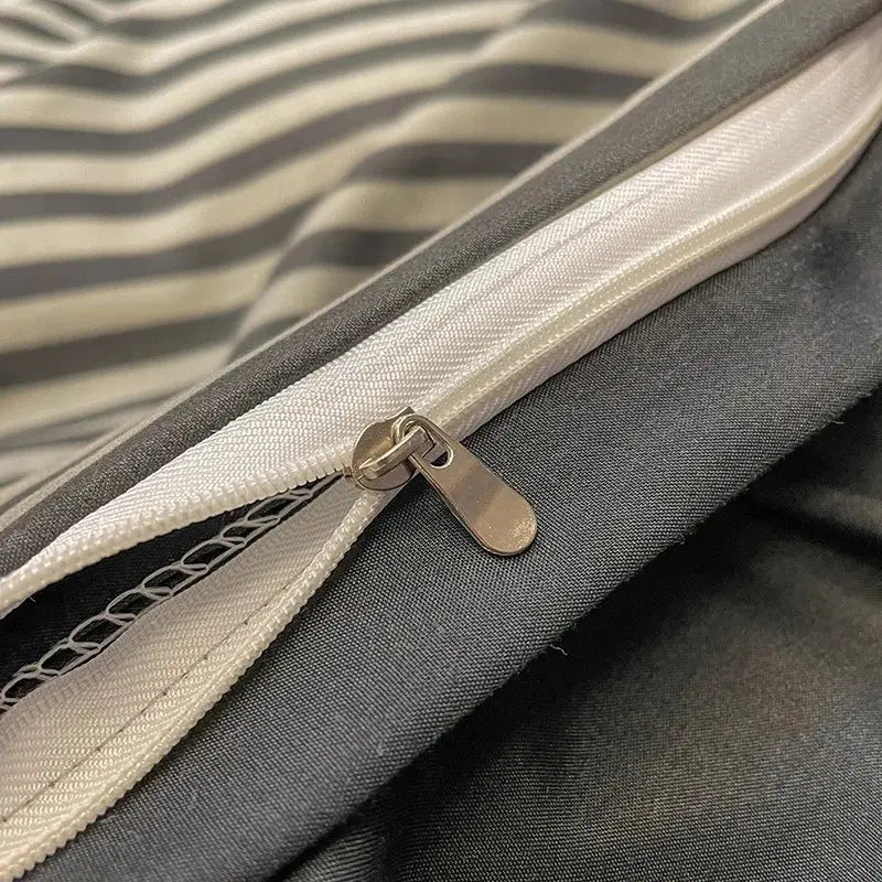 Silver-toned zipper with metallic pull tab on gray and white striped fabric of decorbites nordic plaid cotton bedding set