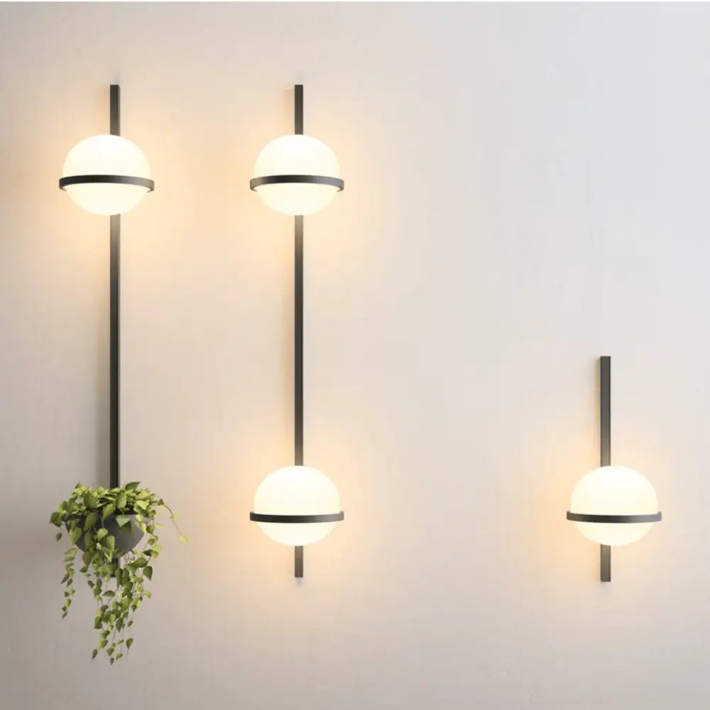 DecorBites™ nordic planter light sconce with matte black rods, frosted glass globes, and a hanging green plant