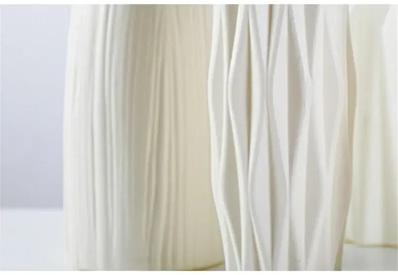 Cream-colored nordic plastic vase with elegant vertically ribbed and wavy textured surface for modern home decor
