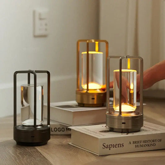 Modern minimalist nordic rechargeable table lamp with sleek metal frame and clear glass emitting warm golden glow