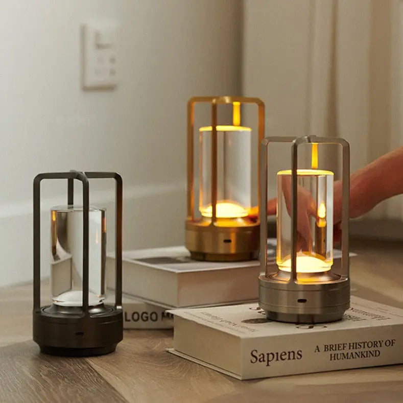 Modern minimalist nordic rechargeable table lamp with sleek metal frame and clear glass emitting warm golden glow