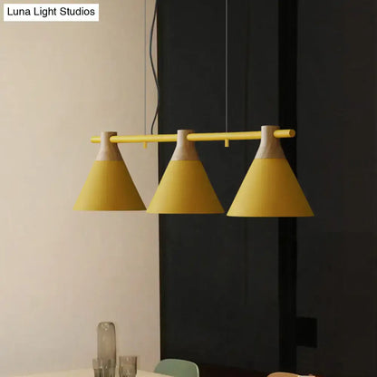 Yellow nordic style pendant light with three conical metal shades and wooden accents hanging from adjustable chain cord length bar