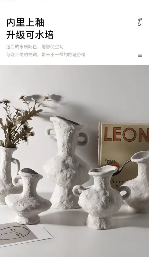 A collection of white nordic style ceramic flower pots with textured surfaces and handles in varied shapes by decorbites