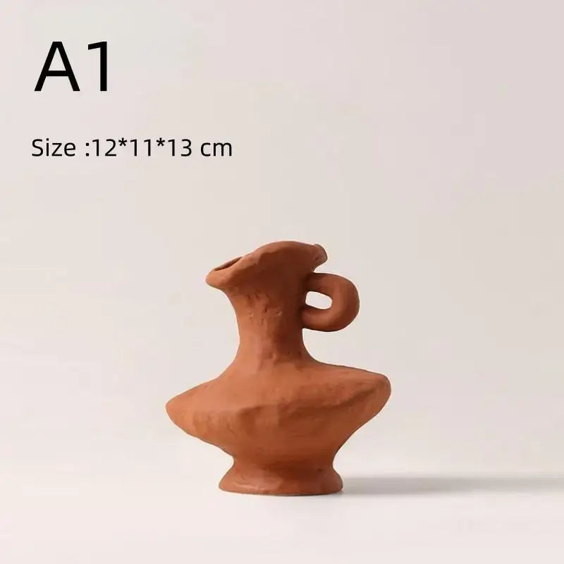 A rustic terracotta ceramic pitcher with curved handle and flared spout beside decorbites™ nordic style ceramic flower pot white