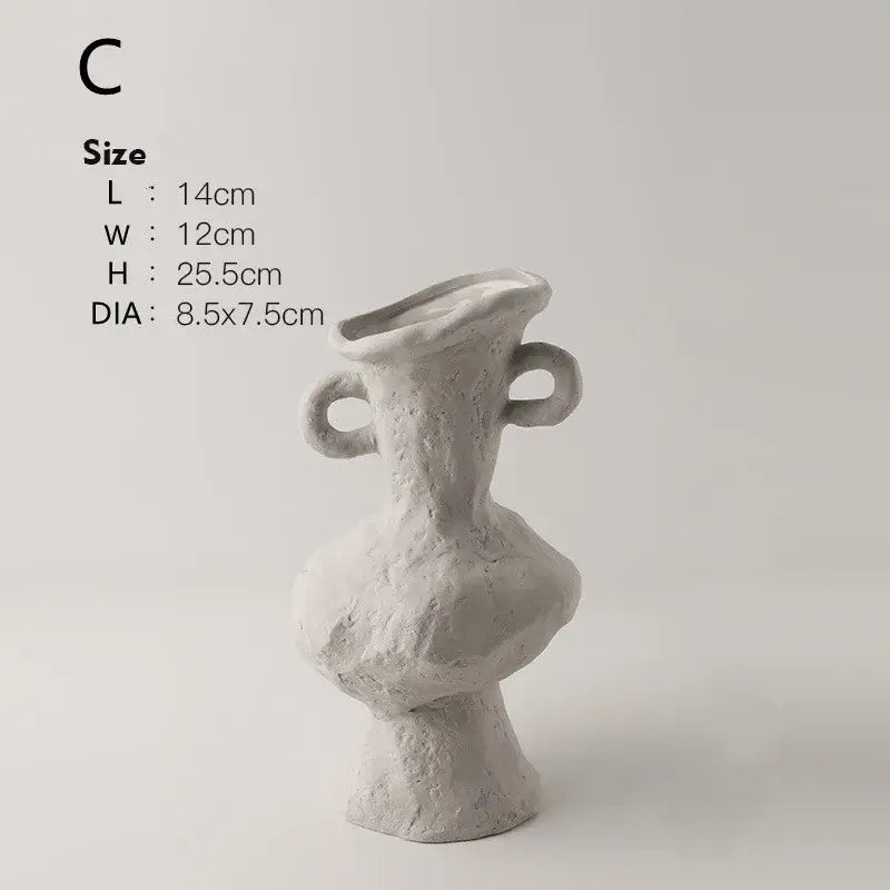 A textured off-white nordic style ceramic flower pot with two looped handles and an asymmetrical sculptural form by DecorBites