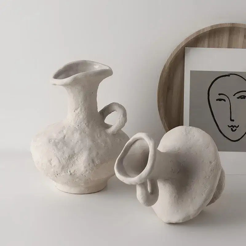 Two off-white nordic style ceramic flower pots with textured organic forms and integrated handles by decorbites