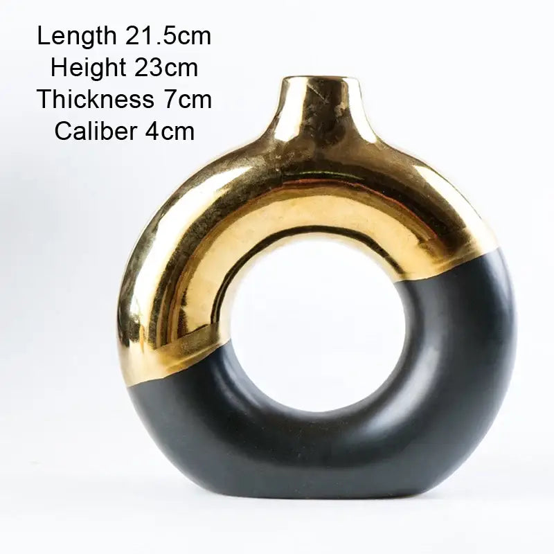 A sleek nordic style circle vase by decorbites with a glossy black and gold ceramic finish for flower arrangement