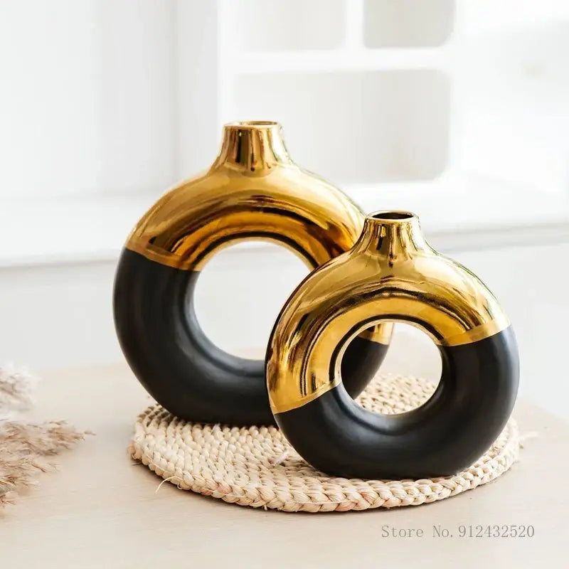 Two sleek modern ceramic nordic style circle vases in bold black and gold for flower arrangement by decorbites