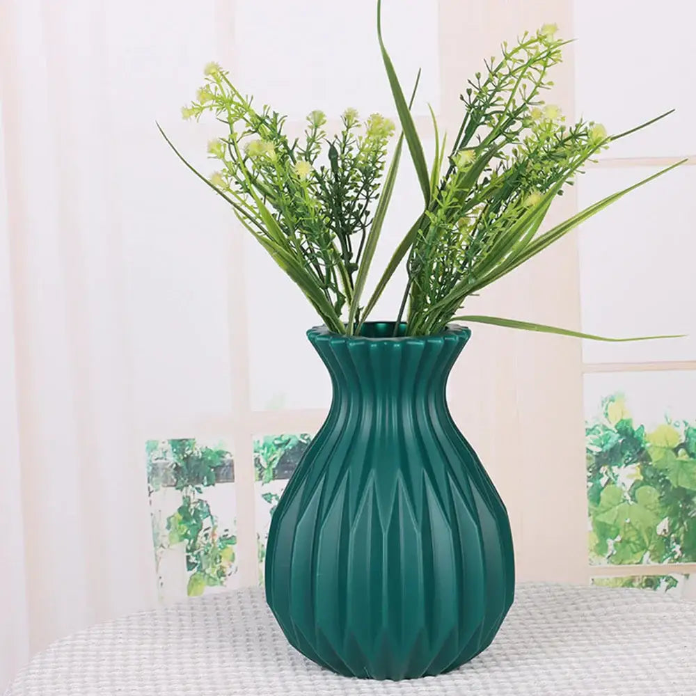 Teal-green ribbed ceramic decorbites™ flower vase holding artificial plastic flower greenery for home decor