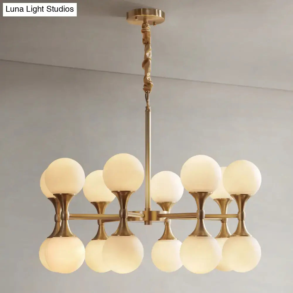 Decorbites opal glass chandelier light with 12 brass frosted globe heads in a modern symmetrical design