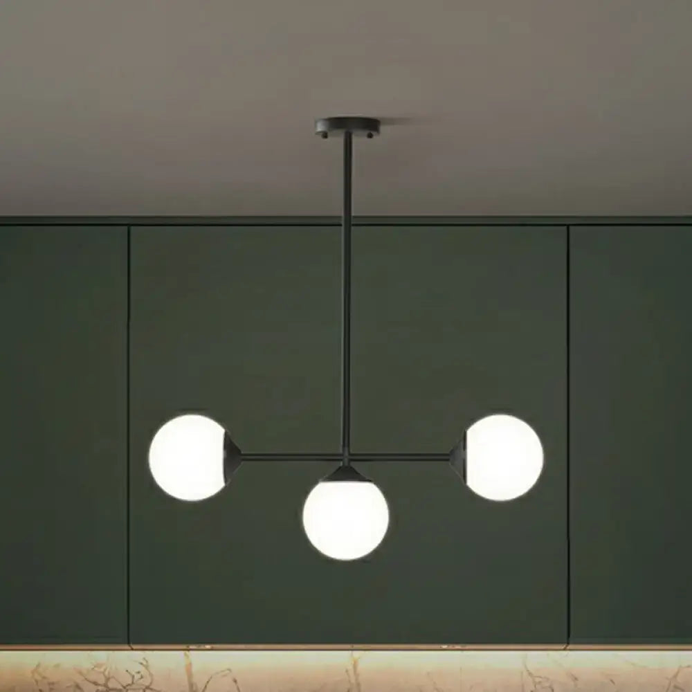 Modern black metal chandelier with three frosted opaline glass globes for minimalist dining room island lighting