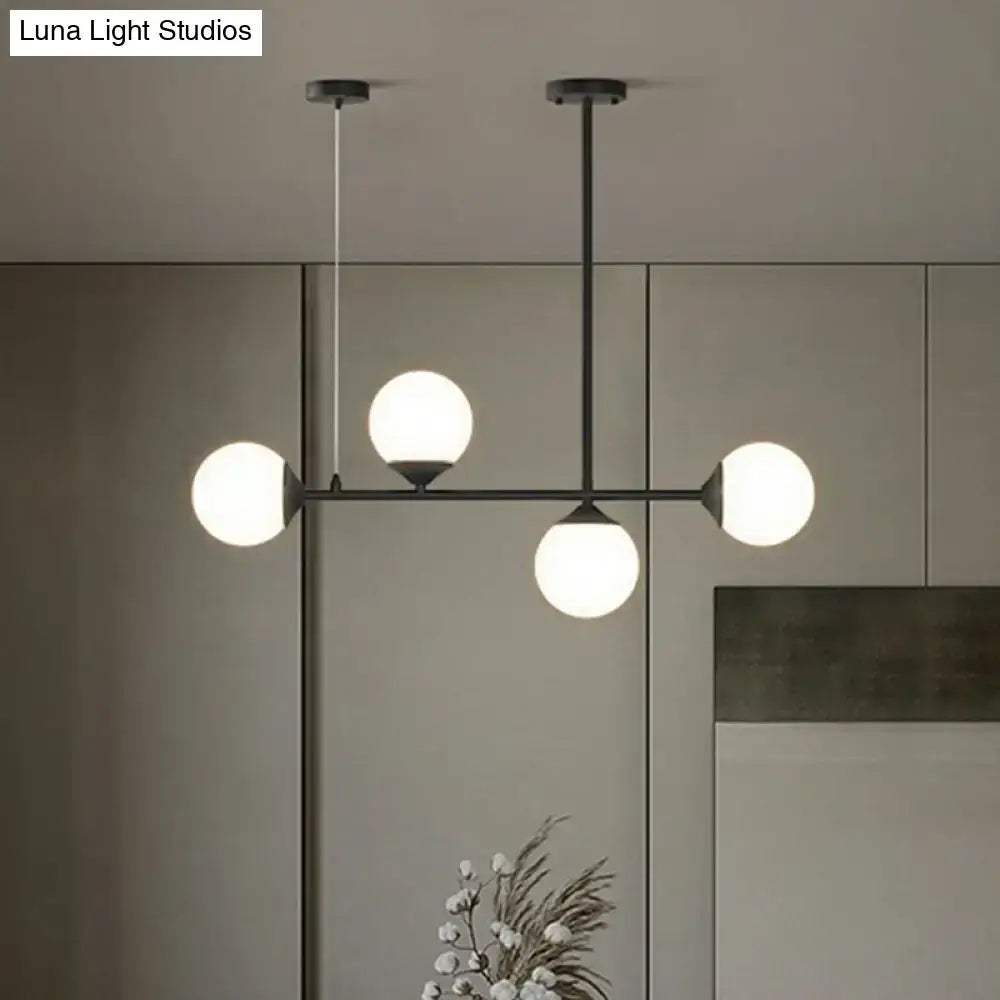 Modern black metal DecorBites pendant light with four frosted opaline glass globes for minimalist dining room island