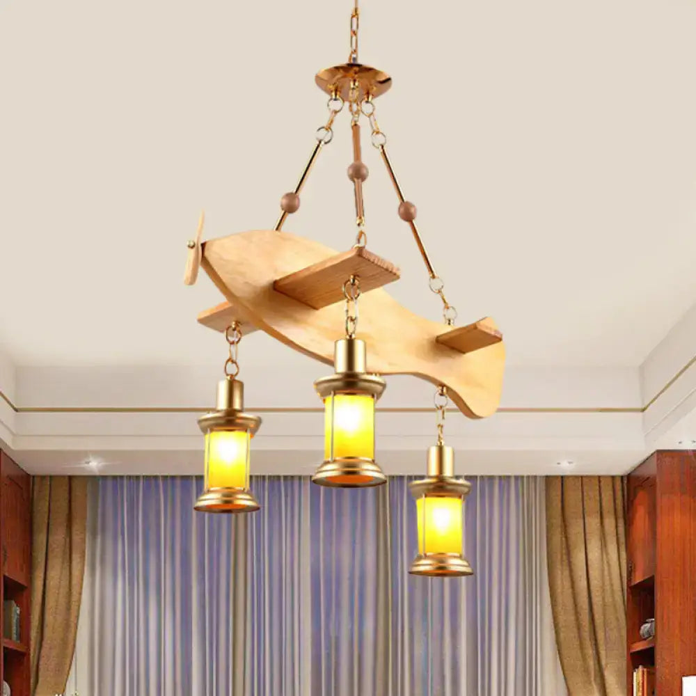 A rustic wooden airplane chandelier with brass accents and three warm yellow lanterns in a fish guitar design pendant light