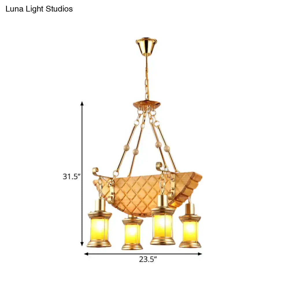 Gold-toned pendant light with woven basket frame and four lanterns featuring fish guitar design and orange glass accents