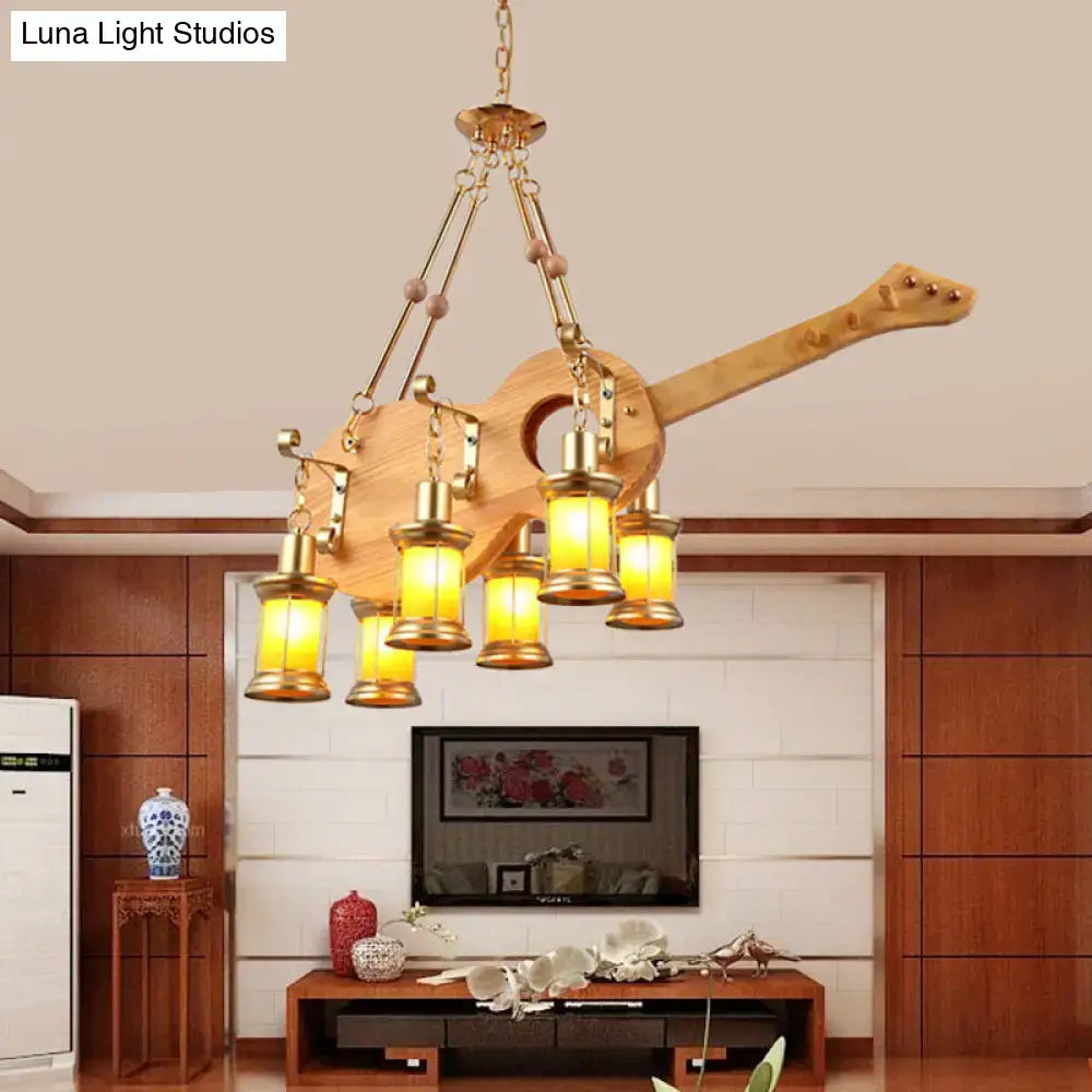 DecorBites™ pendant light in rustic wood with fish guitar design, brass accents, and warm orange glass shades