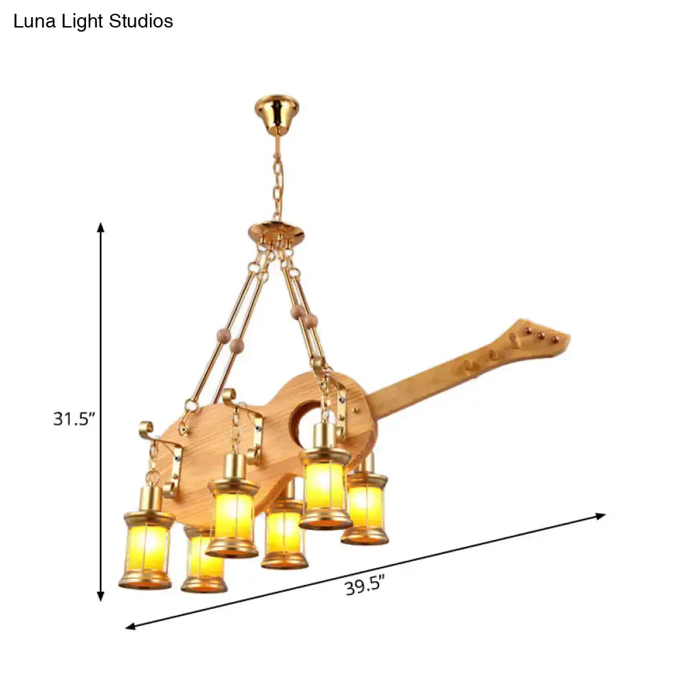 Decorbites pendant light with fish guitar design featuring golden brass accents and six warm orange glass lanterns