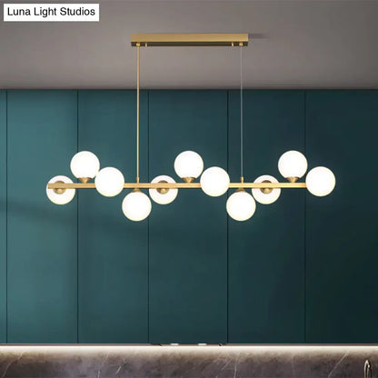 Modern gold-toned decorbites™ orb pendant light with multiple white glass shade globes in an asymmetrical design